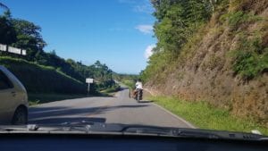 Moto com 2 passageiros, sem capacete em estrada sem acostamento - República Dominicana