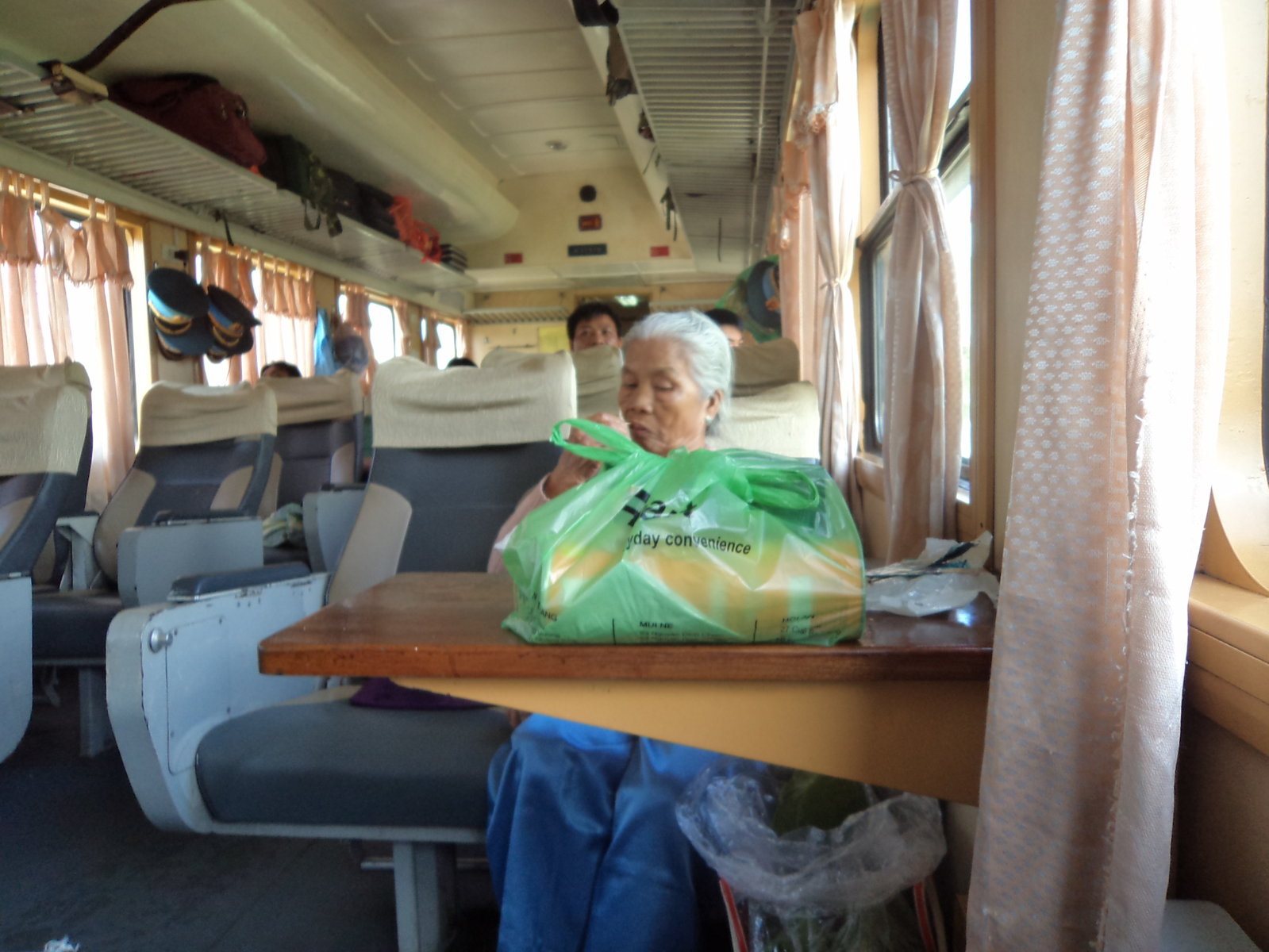 Senhora vietnamita limpando a mão na cortina do trem