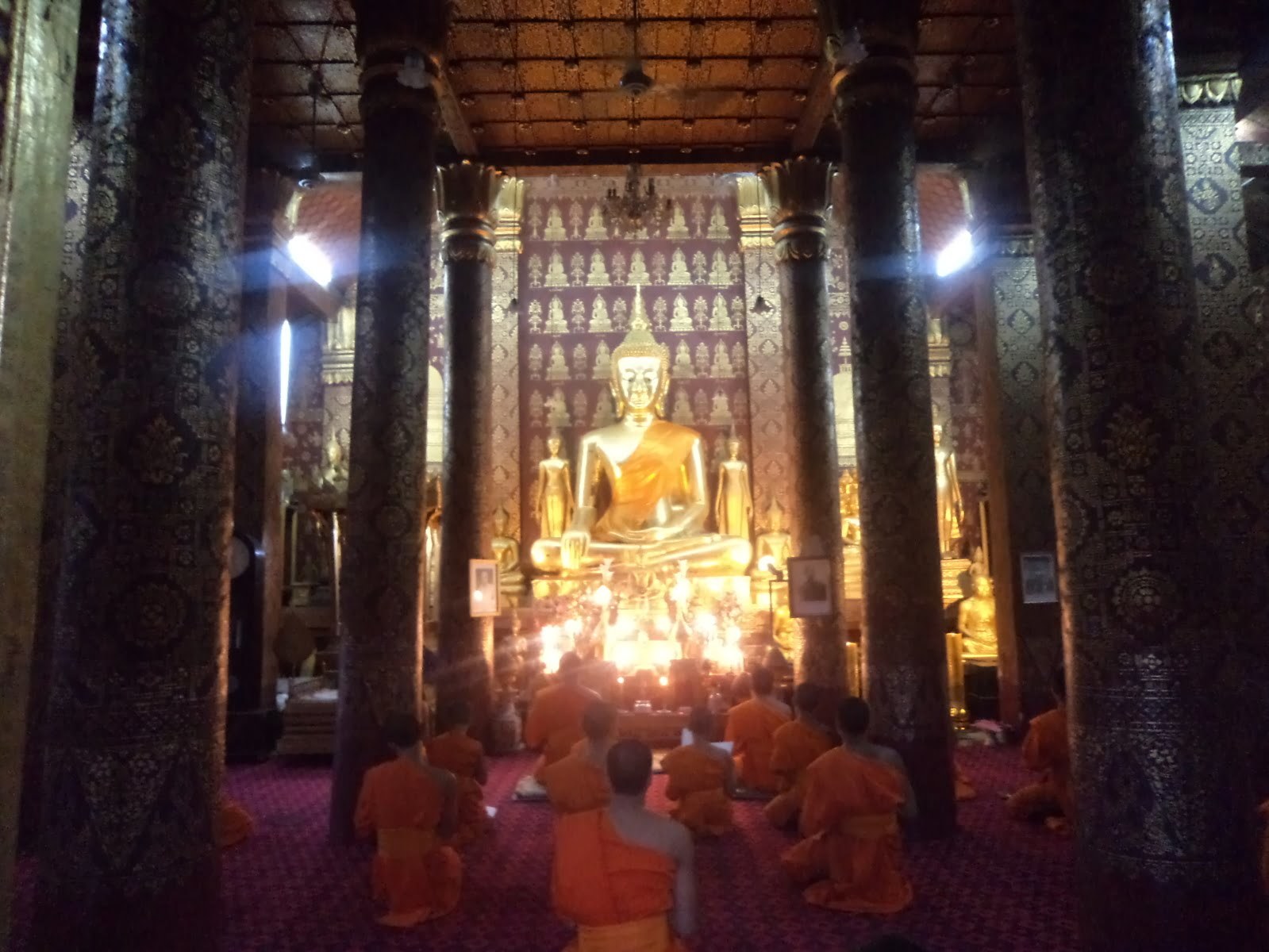 Monges rezam no templo ao pé do Mount Phousi - Luang Prabang, Laos
